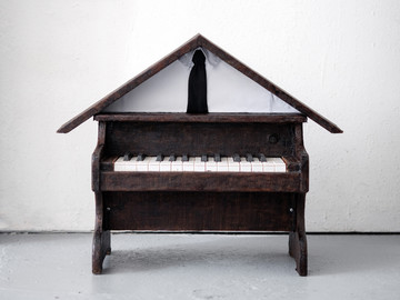 Kay Yoon, Tuning House, 2026, presented by CAPTION , Toy piano, wood, shirt, tie, lacquer, 60x24x48cm - © Courtesy of the artist, Paris Internationale